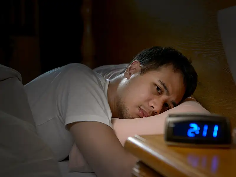 A man being kept awake at night by anxiety